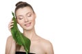 Beautiful woman with clean skin smiling holds a green leaf in her hands. Skin care concept