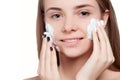 Beautiful woman cleaning face with foam treatment light background Royalty Free Stock Photo