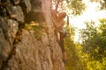 Beautiful Woman Climbing on the Rock at Foggy Sunset in the Mountains. Adventure and Extreme Sport Concept Royalty Free Stock Photo