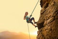 Beautiful Woman Climbing on the Rock at Foggy Sunset in the Mountains. Adventure and Extreme Sport Concept Royalty Free Stock Photo