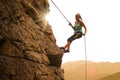 Beautiful Woman Climbing on the Rock at Foggy Sunset in the Mountains. Adventure and Extreme Sport Concept Royalty Free Stock Photo