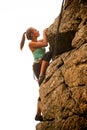 Beautiful Woman Climbing on the Rock at Foggy Sunset in the Mountains. Adventure and Extreme Sport Concept Royalty Free Stock Photo