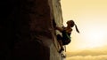 Beautiful Woman Climbing on the Rock at Foggy Sunset in the Mountains. Adventure and Extreme Sport Concept Royalty Free Stock Photo