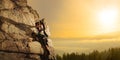 Beautiful Woman Climbing on the Rock at Foggy Sunset in the Mountains. Adventure and Extreme Sport Concept Royalty Free Stock Photo