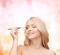 Beautiful woman with closed eyes and makeup brush Royalty Free Stock Photo