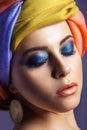 Beautiful woman with colored headwear and blue makeup. Royalty Free Stock Photo