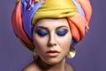 Beautiful woman with colored headwear and blue makeup. Royalty Free Stock Photo