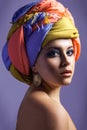 Beautiful woman with colored headwear and blue makeup. Royalty Free Stock Photo