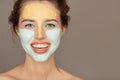 Beautiful woman with colorful cream mask on her face