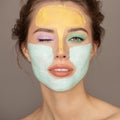 beautiful woman with colorful cream mask on her face
