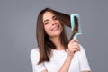 Beautiful woman combs her healthy hair. Combing healthy long straight female hair, close up. Attractive gorgeous Royalty Free Stock Photo