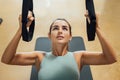 Beautiful woman concentrated with suspension strap workout at gym hiit class. Royalty Free Stock Photo