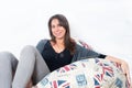 Beautiful woman 30-40 on a confortable sofa with british printart looking to the camera