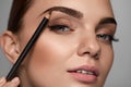 Beautiful Woman Contouring Eyebrows With Pencil. Beauty