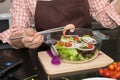 Beautiful woman cooking in new kitchen making healthy food with Royalty Free Stock Photo