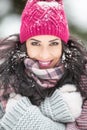 Beautiful woman covered in snow cuddles herself in winter cold smiling at the camera Royalty Free Stock Photo