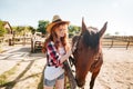 Beautiful woman cowgirl taking care of her horse on farm Royalty Free Stock Photo