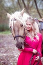 Beautiful woman in crown, blonde with light gray horse. Princess in fairy tale.