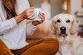 beautiful woman and cute golden retriever dog enjoying healthy breakfast at home, lying on the floor. healthy breakfast with tea, Royalty Free Stock Photo