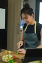 Woman cutting apple on wooden board while preparing healthy breakfast in kitchen. Royalty Free Stock Photo