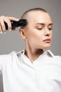 Beautiful woman cutting her hair. bald Girl with hairclipper Royalty Free Stock Photo