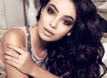 Beautiful woman with dark curly hair and evening makeup