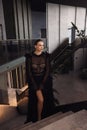beautiful woman with dark hai in elegant black dress posing in luxury hotel hall Royalty Free Stock Photo