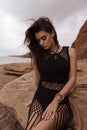 beautiful woman with dark hair in casual clothes posing in desert of Cyprus