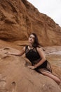 beautiful woman with dark hair in casual clothes posing in desert of Cyprus