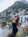 beautiful woman with dark hair in elegant clothes posing against the backdrop of the city Positano in Italy Royalty Free Stock Photo