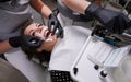 Beautiful woman in dental chair during procedure of installing braces to upper and lower teeth