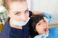 Beautiful woman dentist examining female patient teeth