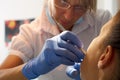 Beautiful woman dentist treating a patient's teeth in dental office