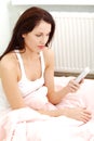 Beautiful woman dialing a phone number in the bed. Royalty Free Stock Photo