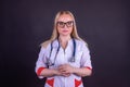 A beautiful woman doctor in a medical gown with glasses and a stethoscope around her neck Royalty Free Stock Photo