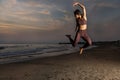 Beautiful woman does fitness on the beach at sunset. Royalty Free Stock Photo