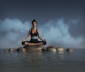 Beautiful woman does meditation and Yoga poses on a rock