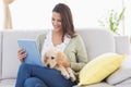 Beautiful woman with dog using digital tablet on sofa Royalty Free Stock Photo