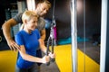 Beautiful woman doing exercises in gym with personal trainer Royalty Free Stock Photo