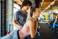 Beautiful woman doing exercises in gym with personal trainer together. Sport, people concept Royalty Free Stock Photo