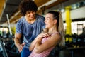 Beautiful woman doing exercises in gym with personal trainer together. Sport, people concept Royalty Free Stock Photo