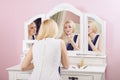 Beautiful woman is doing makeup in front of mirror. Royalty Free Stock Photo