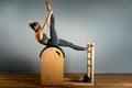 Beautiful woman doing pilates exercise, training on barrels. Barrel reformer, correct posture, healthy locomotor system. Royalty Free Stock Photo