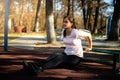 Beautiful woman doing sport on outdoor park during fall and sunset - triceps exercise Royalty Free Stock Photo