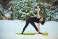 Beautiful woman doing yoga outdoors in snow Royalty Free Stock Photo