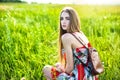 Beautiful woman in dress and bag sitting on the glade