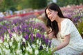 beautiful woman in dress enjoying Angelonia flower blooming in field