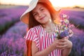 Lavender field and beautiful woman with dress and hat enjoying color lavender rows in endless blooming fields