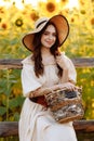 Beautiful woman in a dress and hat in a field of sunflowers Royalty Free Stock Photo