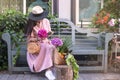 Beautiful woman in a dress with purchases, sits on a bench in the city street. A large basket of vegetables and flowers in the Royalty Free Stock Photo